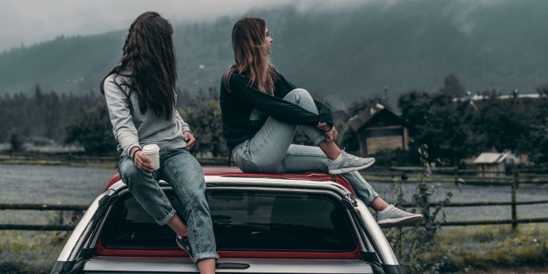 young drivers sitting on the back of a vehicle